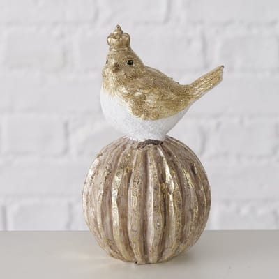 Schattig beeld van een vogel met kroontje zittend op een bol goudkleurig