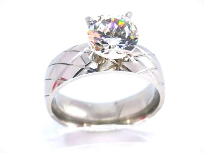 Prachtige ring maat 18 edelstaal met fonkelend kwaliteit zirkonia van Ø 8 mm, steen is op 4 pootjes gezet en het ring zelf is met ruitenmotief bewerkt.