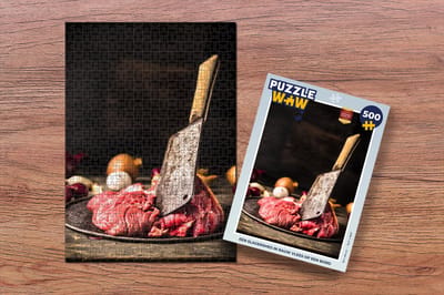 Puzzel Een slagersmes in rauw vlees op een bord - Legpuzzel - Puzzel 500 stukjes