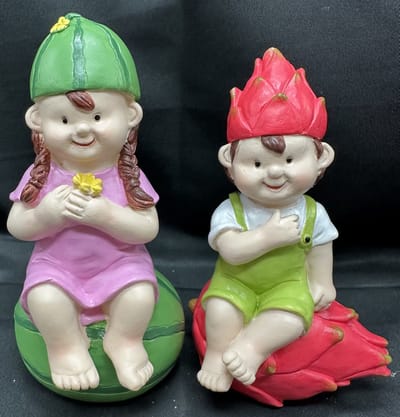 Polyresin tropische (tuin) kinderen " Meisje op watermeloen + Jongen op dragon fruit " - Set van 2 stuks - meerkleurig - Hoogte 15 x 10 x 6 cm - Woonaccessoires - Tuinaccessoires - Tuindecoratie