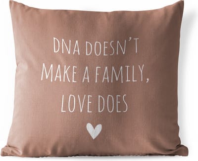 Buitenkussen Weerbestendig - Engelse quote "DNA doesn't make a family, love does" met een hartje tegen een bruine achtergrond - 50x50 cm