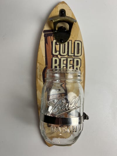 Opener voor aan de wand met ludieke glazen “doppen-pot”