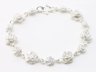 Zware zilveren armband met roosjes met witte emaille