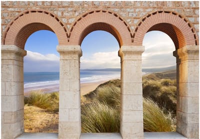 Fotobehangkoning - Behang - Vliesbehang - Fotobehang Uitzicht op het Strand door de Romeinse Pilaren 3D - 150 x 105 cm
