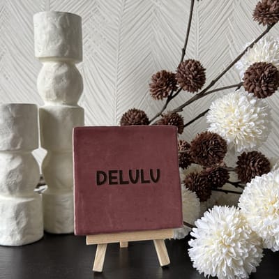 Hartjespost | Tegeltje Delulu rood, bruin | schoencadeautjes sinterklaas | tegeltjes met tekst | spreuktegel | tegeltjeswijsheden | cadeau | Christmas | Xmas | kerstmis | decoratie kerst | delulu | delusional | 10x10