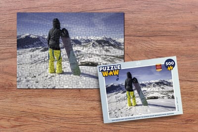 Puzzel Een meisje met snowboard staat te kijken naar besneeuwde bergen - Legpuzzel - Puzzel 500 stukjes
