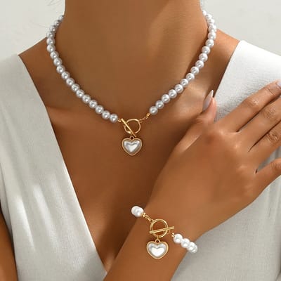 Sjika - Gold plated parelset met hart hanger – Luxe ketting & armband dames – Elegant & romantisch design – Perfect cadeau voor haar