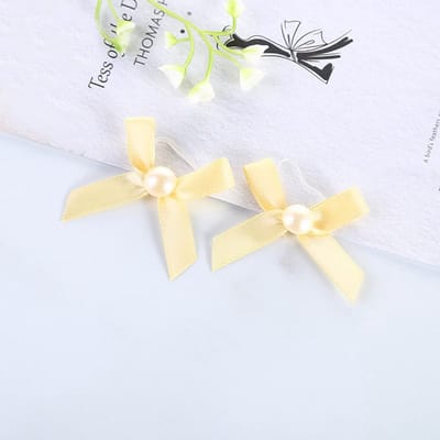 Set van 50 kleine parelstrikken met transparante elastiek voor cadeauverpakking - bruiloft, decoratie, geschenk - goudkleurig.