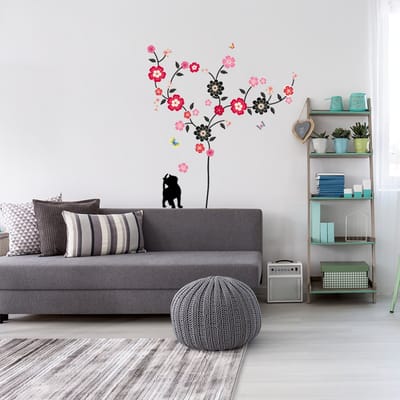 Decoratieve muurstickers met een bloeiende boom, een kat en vlinders.