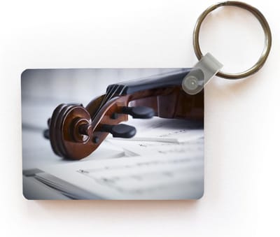 Sleutelhanger - Viool van dichtbij weergegeven op boeken bladmuziek - Uitdeelcadeautjes - Plastic