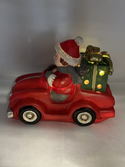 Kerstbeeldje jongen in rode auto met LED - groene cadeau - polyresin - 12 cm hoog x 16 cm x 8 cm – Kerstdecoratie