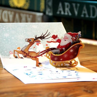 3D pop up Kerstkaart  Vrolijke Kerstman op een arrenslee met rendier pop-up wenskaart met Berichtenpaneel - Voordeelpakket