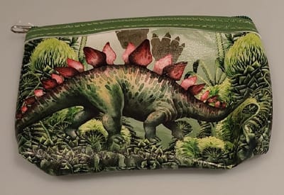 Gemakkelijk om erbij te hebben, dit handige rits portemonneetje met een afbeelding rondom van een dino. Geschikt voor bijvoorbeeld pasjes, muntgeld, briefgeld, bonnetjes of oordopjes. Voor uzelf of als Cadeau.