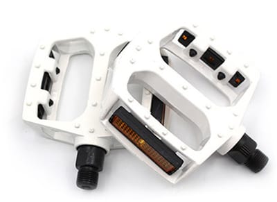 Een paar witte, antislip fietspedalen met reflecterende strips. Mountainbikepedalen met kogellageraandrijving.