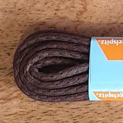 Ringpoint - donker bruin - 60 cm - Klassieke gewaxte medium dikke schoenveters van het duitse merk Ringelspitzen; de veters met het gouden ringetje op de nestel.
