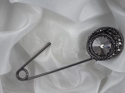 Speld, zwartkleur met grote antraciet zirkonia en omring door zwart strass steentjes.