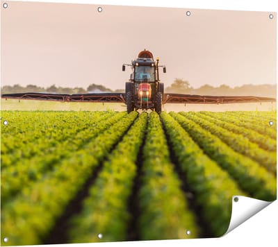 Gards Tuinposter Rode Tractor op het Veld aan het Sproeien - 120x90 cm - Tuindoek - Tuindecoratie - Wanddecoratie buiten - Tuinschilderij