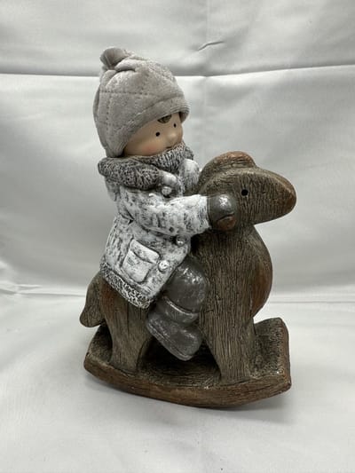 Kerstbeeld jongen op hobbelpaard - Wit+grijs + taupe stoffen muts - polyresin - 23x16x6cm - Kerstdecoratie