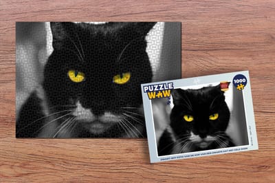 Puzzel Zwart-wit foto van de kop van een zwarte kat met gele ogen - Legpuzzel - Puzzel 1000 stukjes volwassenen