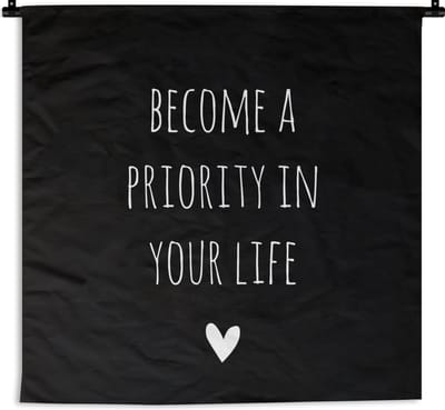 Wandkleed - Wanddoek - Engelse quote "Become a priority in your life" met een hartje tegen een zwarte achtergrond - 60x60 cm - Wandtapijt