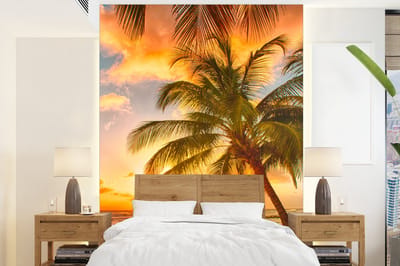 Behang - Fotobehang Zonsondergang - Palmboom - Wolken - Zee - Strand - Breedte 160 cm x hoogte 220 cm