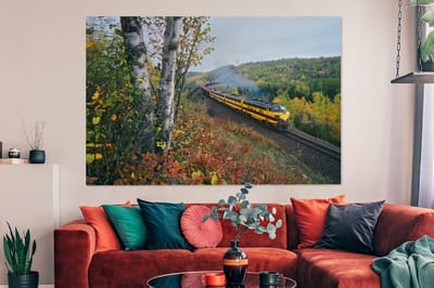 Canvas schilderij 150x100 cm - Wanddecoratie Een gele stoomtrein in een groen landschap - Muurdecoratie woonkamer - Slaapkamer decoratie - Kamer accessoires - Schilderijen