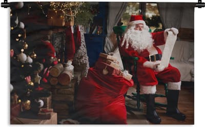 Wandkleed Kerst - De kerstman zittend in een stoel met zak vol geschenken Wandkleed katoen 180x120 cm - Wandtapijt met foto XXL / Groot formaat!