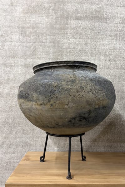 Ronde aardewerk pot op statief grijs landelijke kruik bloempot met zwart metalen statief