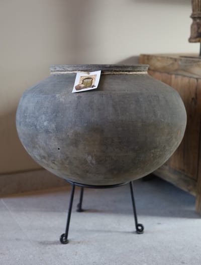 Ronde aardewerk pot op statief donker grijs landelijke kruik bloempot met zwart metalen statief