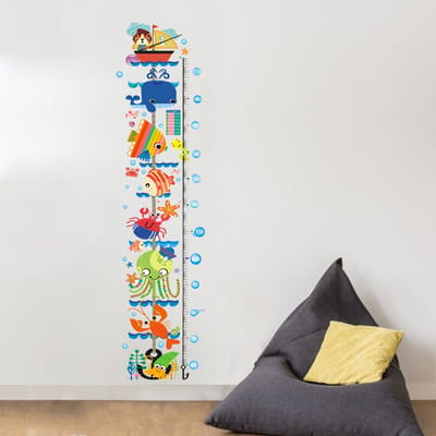 Decoratieve muurstickers met een groeimeter, een boot en zeedieren.
