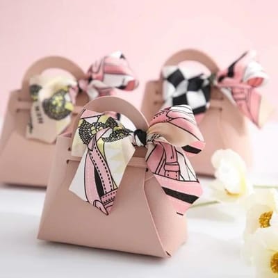 Distribuez des sacs cadeaux en cuir rose, des sacs de faveur de mariage pour les invités, un mini sac à main avec un ruban, une boîte d'emballage de bonbons, une décoration de fête rose