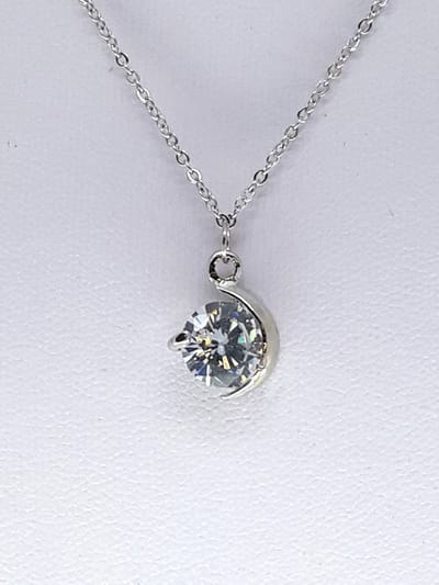 Ketting met zirkonia steen hanger, met "half-moon" zetting. Sieraad staat bekend om zijn minimalistische en elegante uitstraling, waarbij de steen centraal staat.