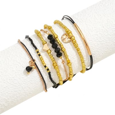 Set van 7 armbanden voor dames met goudkleurige en zwarte kralen, bedels en koordaccenten – dames armbanden set in contrasterende tinten