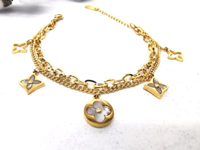 Twee stijlen - één armband - Goudkleurig - RVS - Double Chains - Parelmoer klaver - combineert een verfijnde en grove schakelketting voor een moderne, gelaagde look. Gemaakt van goudkleurig RVS – stijlvol, sterk en waterproof.