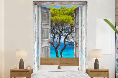 Behang - Fotobehang Boom - Tropisch - Zee - Doorkijk - Strand - Breedte 155 cm x hoogte 240 cm