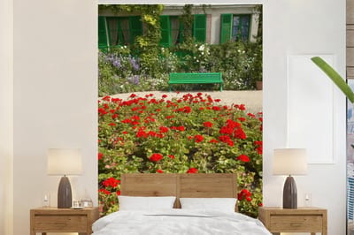 Behang - Fotobehang Bankje met bloemen in de Franse tuin van Monet in Europa - Breedte 170 cm x hoogte 260 cm