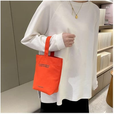 2023 nieuwe minimalistische stijl mini draagbare canvas tas lunchtas snoepkleurige ketel polsband effen canvas tas oranje
