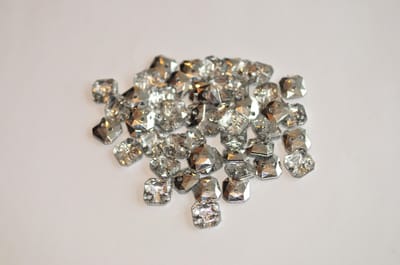 Kristalachtige 2 gaats knoop, Swarovski, vierkant vormig. Doorsnede 10 mm. Mix zakje van 50 stuks.