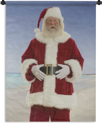 Wandkleed Kerst - De kerstman lacht bij een strand met een grijze hemel Wandkleed katoen 60x80 cm - Wandtapijt met foto