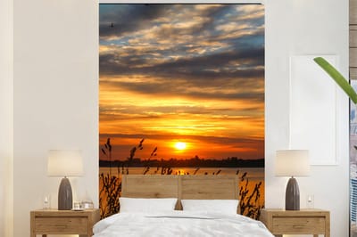 Behang - Fotobehang Zonsondergang - Zee - Horizon - Lucht - Planten - Breedte 170 cm x hoogte 260 cm