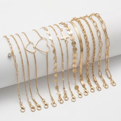Set van 14 goudkleurige armbanden voor dames met diverse schakels, hartjes, muntjes en kruisbedel – dames armbanden set met variatie in stijl