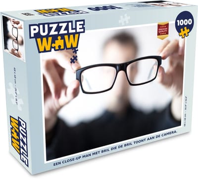 Puzzel Een close-up man met bril die de bril toont aan de camera. - Legpuzzel - Puzzel 1000 stukjes volwassenen