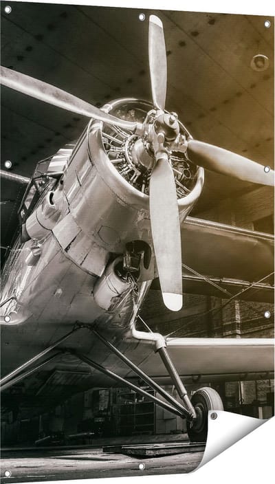 Gards Tuinposter Oud Vliegtuig in een Hangar - Zwart Wit - 80x120 cm - Tuindoek - Tuindecoratie - Wanddecoratie buiten - Tuinschilderij