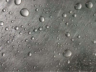Fotobehang - Stalen oppervlak met water druppels.