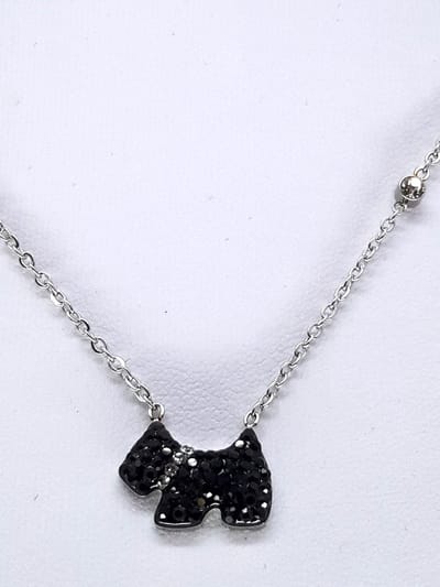 Ketting - RVS - met een hanger in de vorm van een hondje dat is bezet met zwarte steentjes. Sieraad staat bekend om zijn minimalistische en elegante uitstraling,