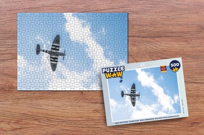 Puzzel Een spitfire vliegtuig van onderen bij een wolkenlucht - Legpuzzel - Puzzel 500 stukjes