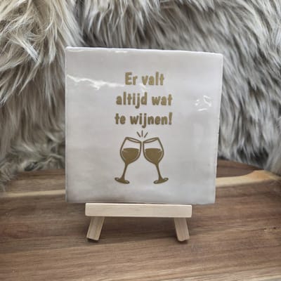 Robuust wenstegeltje "Er valt altijd wat te wijnen!" – Cadeau - Hip trendy tegeltje – Tegeltje met Spreuk – Keramiek – 10x10 cm – Wanddecoratie – Sfeervol en Persoonlijk – Trendy nu – Origineel cadeau - Incl standaard