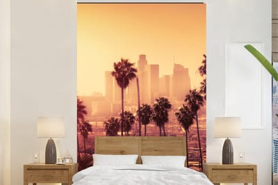 Behang - Fotobehang Palmboom - Skyline - Zonsondergang - Architectuur - Breedte 180 cm x hoogte 280 cm