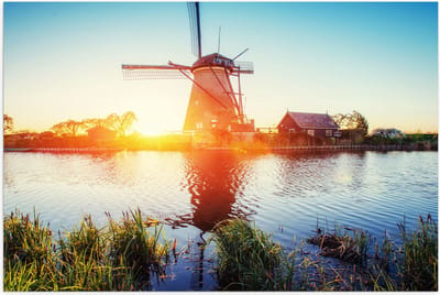 WallClassics - Poster Glanzend – Zonlicht langs Hollandse Molen aan het Water - 75x50 cm Foto op Posterpapier met Glanzende Afwerking