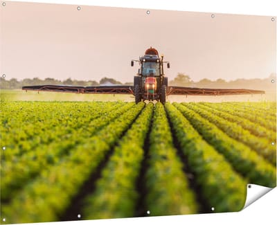 Gards Tuinposter Rode Tractor op het Veld aan het Sproeien - 180x120 cm - Tuindoek - Tuindecoratie - Wanddecoratie buiten - Tuinschilderij